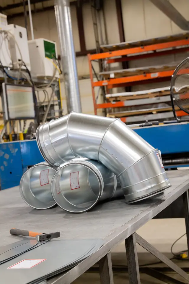 A custom duct elbow and fittings on the fabrication bench in DeKalb Mechanical's own sheet metal shop