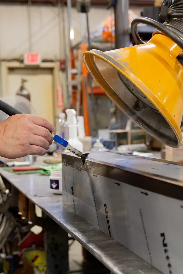 A technician's hands working at the bench in DeKalb Mechanical's sheet metal shop